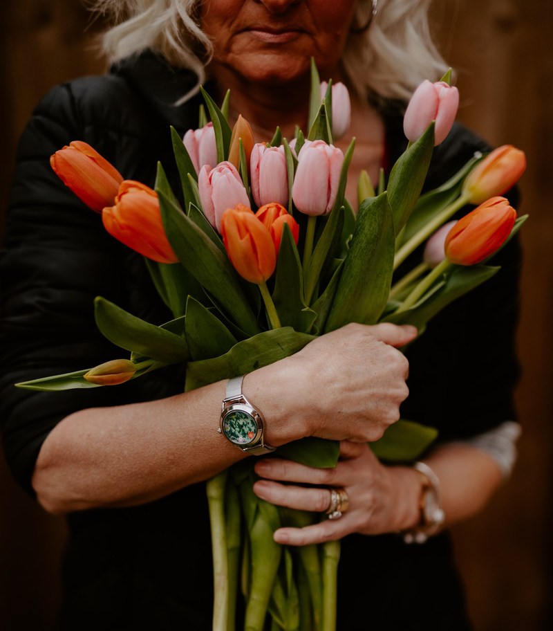 Woman holding flowers wearing Slow Down watch