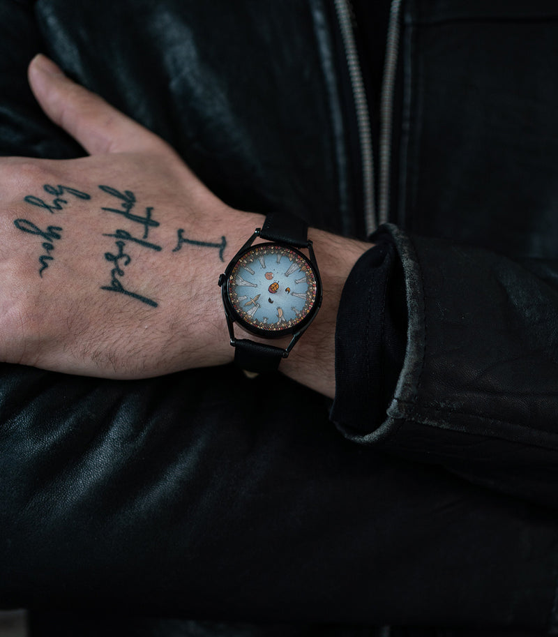 A Perfectly Useless Morning watch worn on tattooed wrist