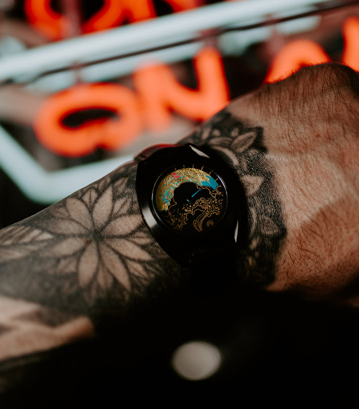 Paper crane watch on tattooed wrist