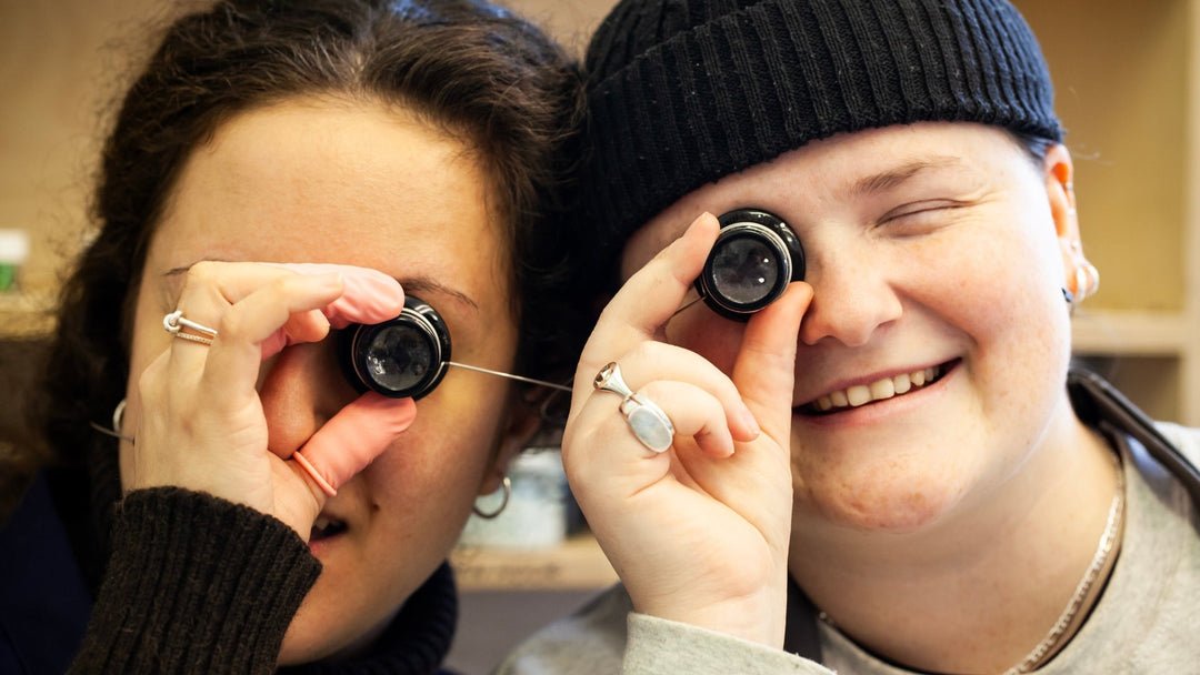 Workshop technicians holding up magnifying glasses to their eyes