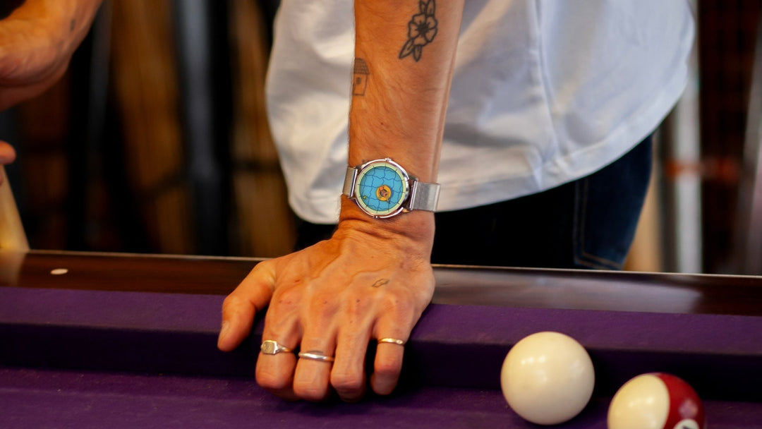 Person leaning on pool table wearing a perfectly useless afternoon watch