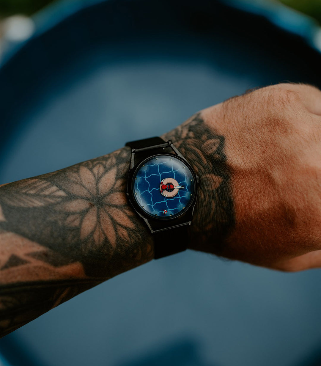 A perfectly useless evening watch worn on wrist in front of a paddling pool