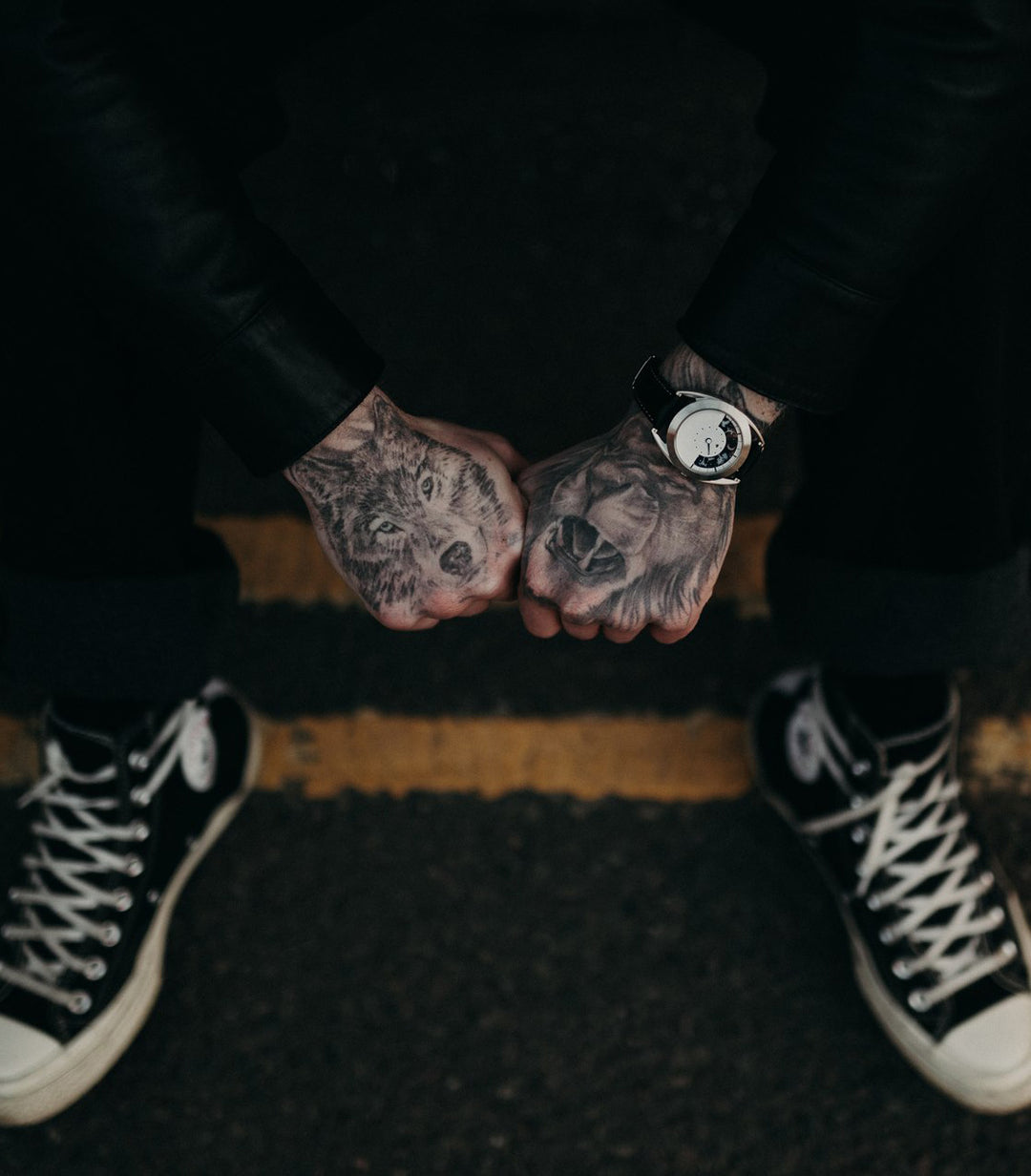 Sun and moon watch on tattooed wrist