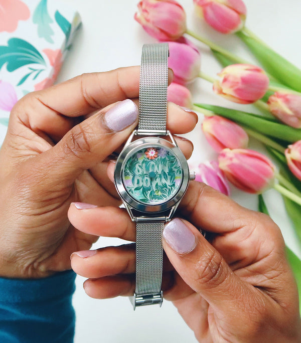 Slow Down watch in hands with flowers